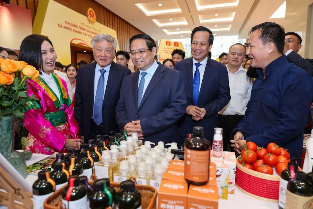 Thủ tướng Phạm Minh Chính, Phó Thủ tướng Thường trực Nguyễn Hòa Bình xem các sản phẩm OCOP trưng bày tại Hội nghị - Ảnh: VGP/Nhật Bắc