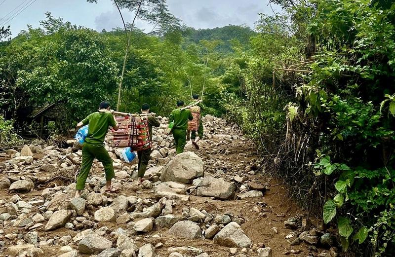 Cán bộ, chiến sĩ Công an Thanh Hóa vượt rừng, lội suối để tiếp tế cho người dân bị cô lập. Ảnh: Minh Phương