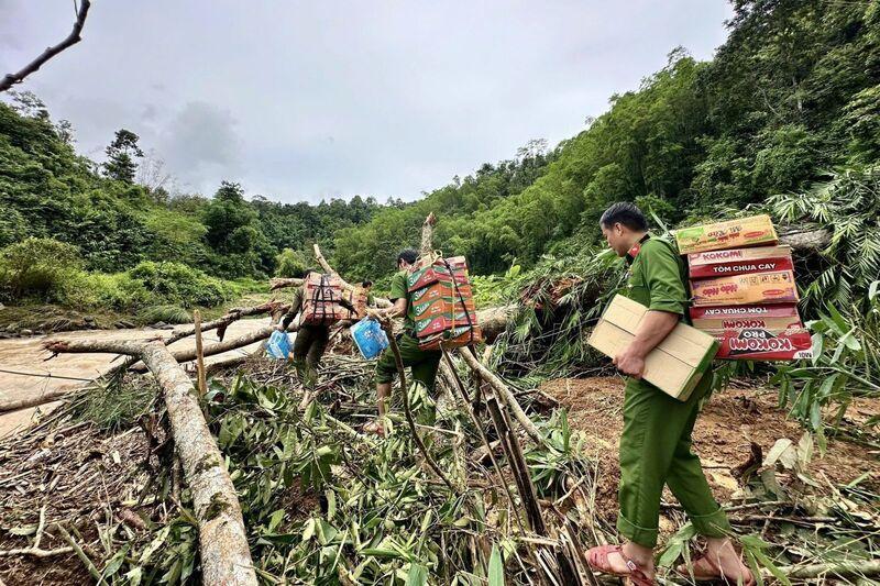 Lực lượng công an mất nhiều giờ, băng rừng, vượt núi hiểm trở tiếp tế nhu yếu phẩm cho người dân bản Pa. Ảnh: Minh Phương
