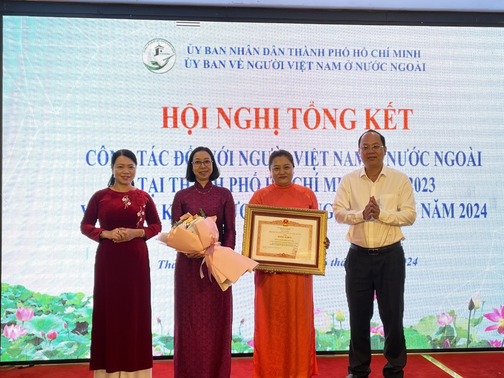 Đồng chí Nguyễn Hồ Hải trao Bằng khen của Thủ tướng Chính phủ đến tập thể Phòng Văn hóa thông tin xã hội, Ủy ban về người Việt Nam ở nước ngoài TPHCM. Ảnh: NGÔ BÌNH