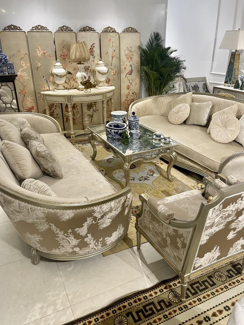 Ảnh phòng khách Chinoiserie đặc sắc với điểm nhấn bộ sofa bọc vải Ý hoạ tiết Chinoiserie, bàn sofa thếp lá bạc và mặt bàn gương vẽ tay Verre Eglomise, bàn console cổ điển white wash theo kỹ thuật gốc của Pháp, bộ bình phong thiết kế của Vivian Thu Nguyen