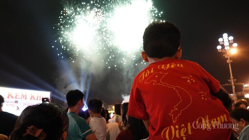 Một cháu bé được bố cõng trên lưng để xem pháo hoa được rõ hơn