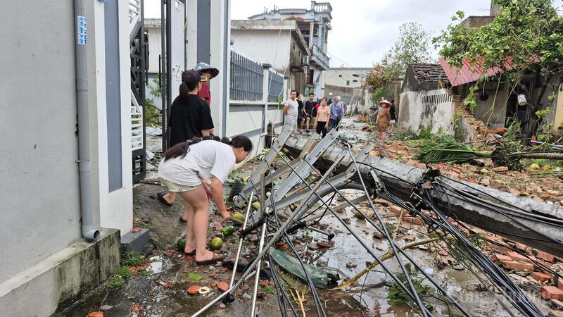 Một cột diện gãy chắn ngang đường, hiện đang chờ lực lượng điện lực đến xử lý