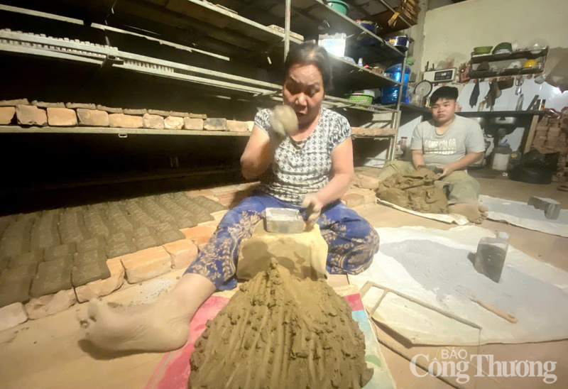 Bà Lê Thị Vân miệt mài nhồi nặn đất thịt đưa vào khuôn in.