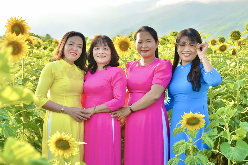 Các chị, các mẹ duyên dáng trong tà áo dài giữa sắc vàng rực rỡ của hoa hướng dương. Ảnh: Ngọc Thảo